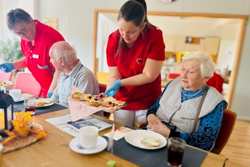 Pflegerin serviert Essen in einem Pflegeheim