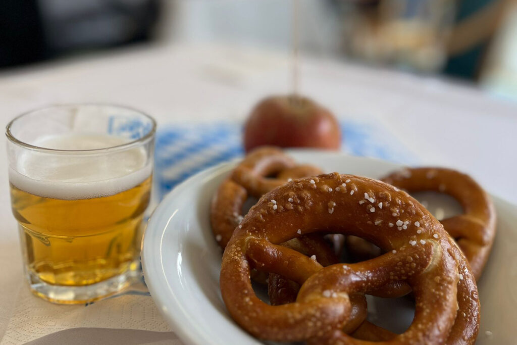 Ein Glas Bier und Brezeln auf einem wei&szlig;en Teller