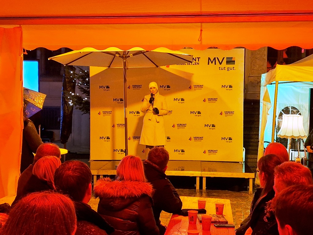 Person auf einer Bühne bei einer Veranstaltung im Freien