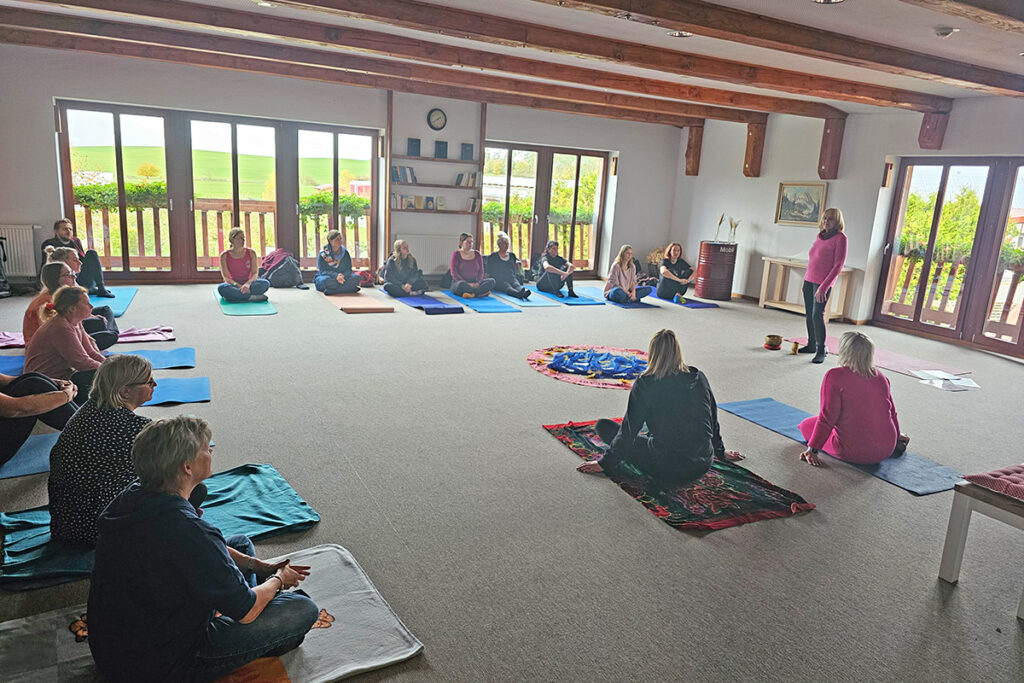 Gruppenaktivit&auml;t in einem hellen Raum mit gro&szlig;en Fenstern.