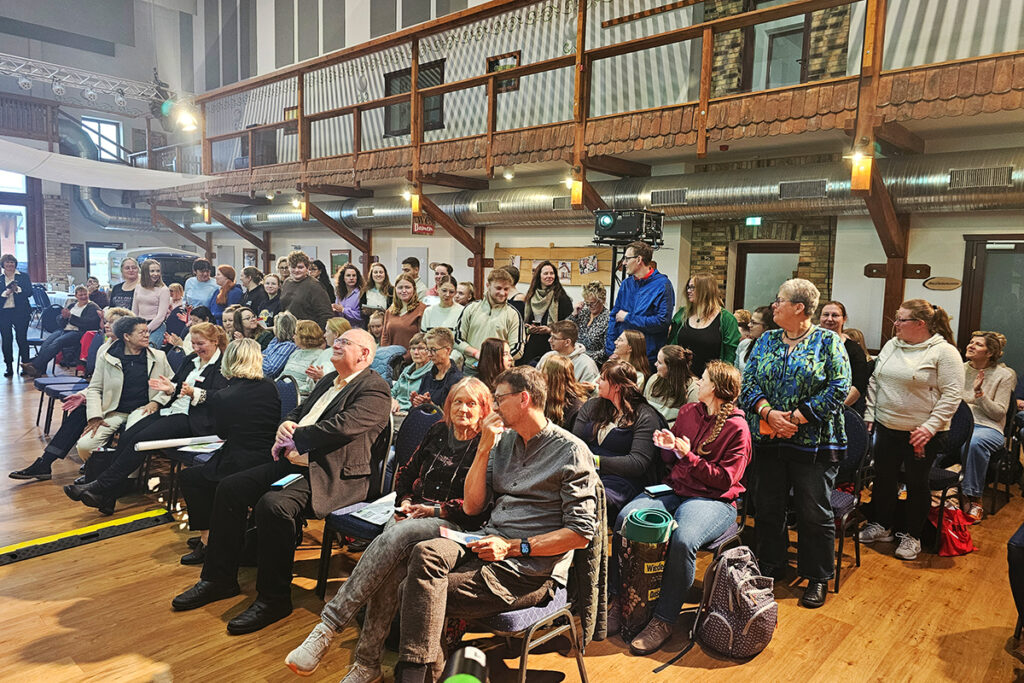 Versammlung von Menschen in einem Veranstaltungsraum.