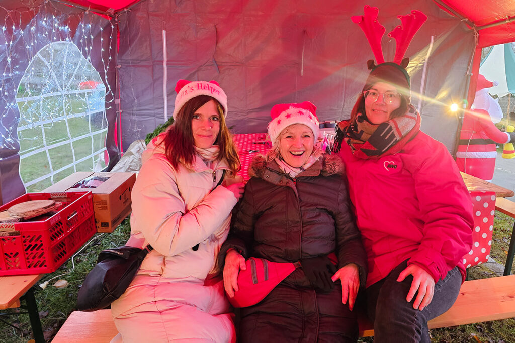 Drei Frauen in einem weihnachtlich dekorierten Zelt