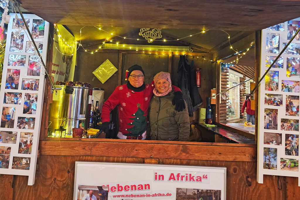 Zwei Personen in weihnachtlicher Umgebung in einer Holzbude