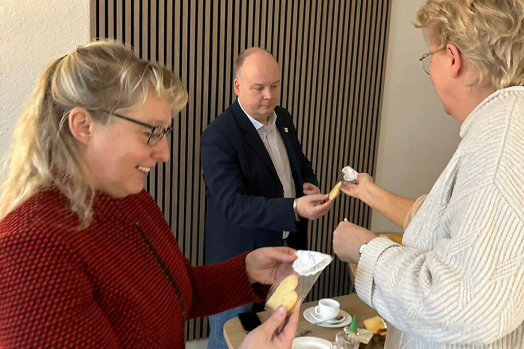 Drei Personen bei einer gem&uuml;tlichen Kaffeepause mit Keksen