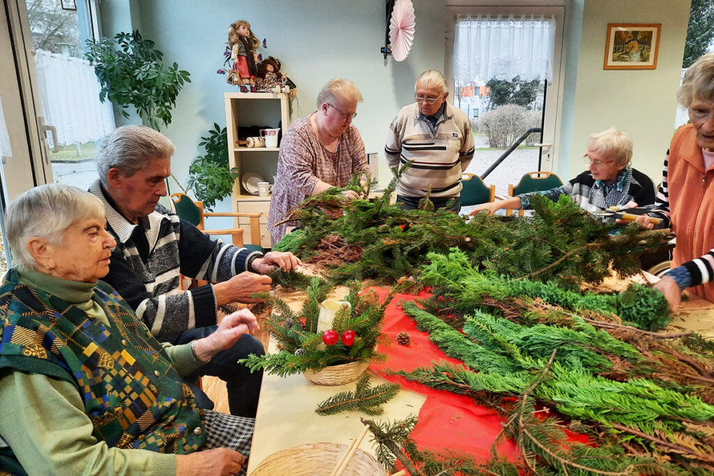 Personen beim Basteln von Adventsdekoration