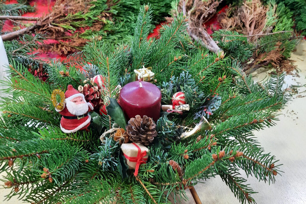 Weihnachtliches Gesteck mit roter Kerze