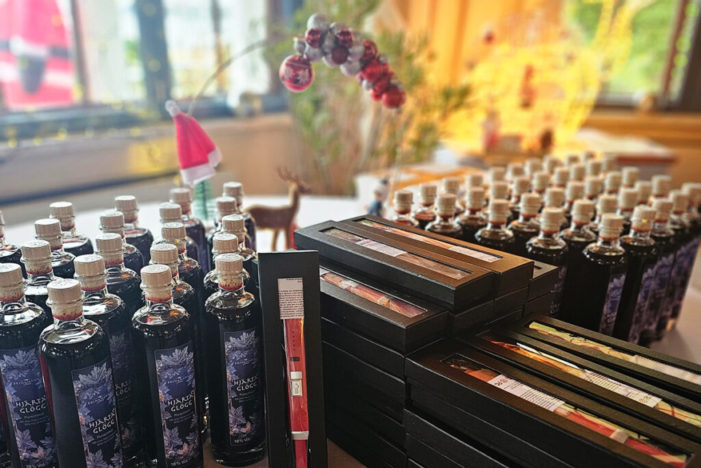 Ein Tisch mit vielen Flaschen und Geschenkboxen in weihnachtlicher Dekoration.