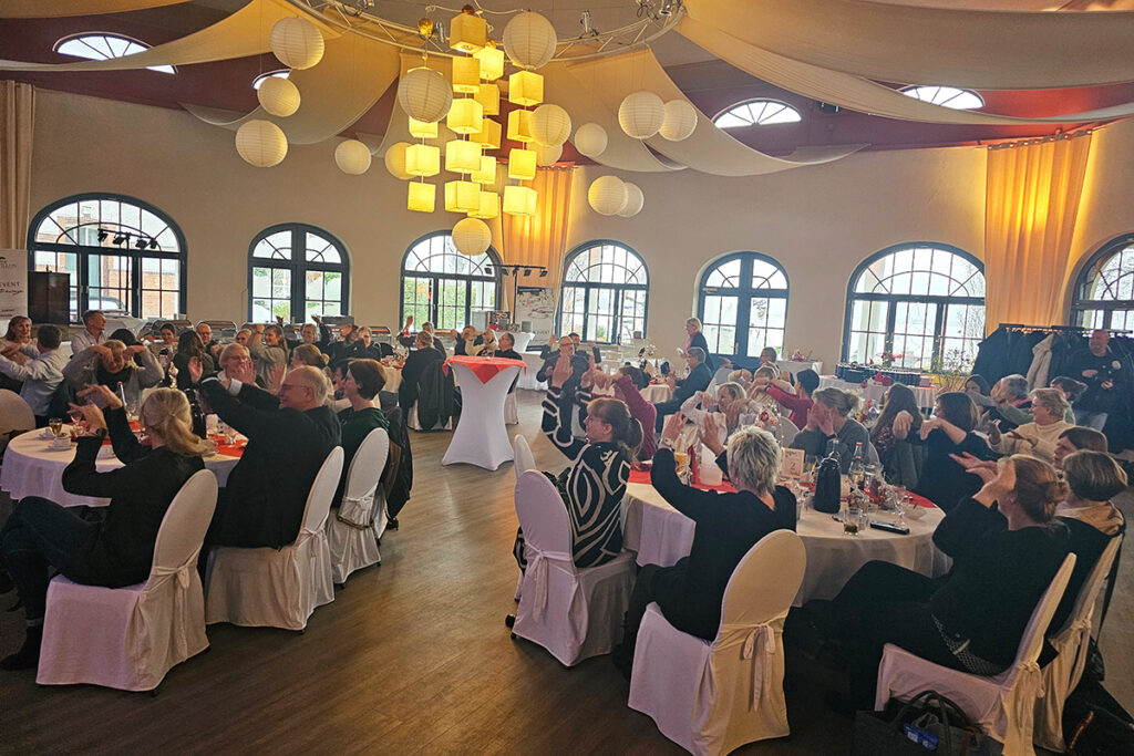 Menschen bei einer Veranstaltung in einem festlich dekorierten Raum