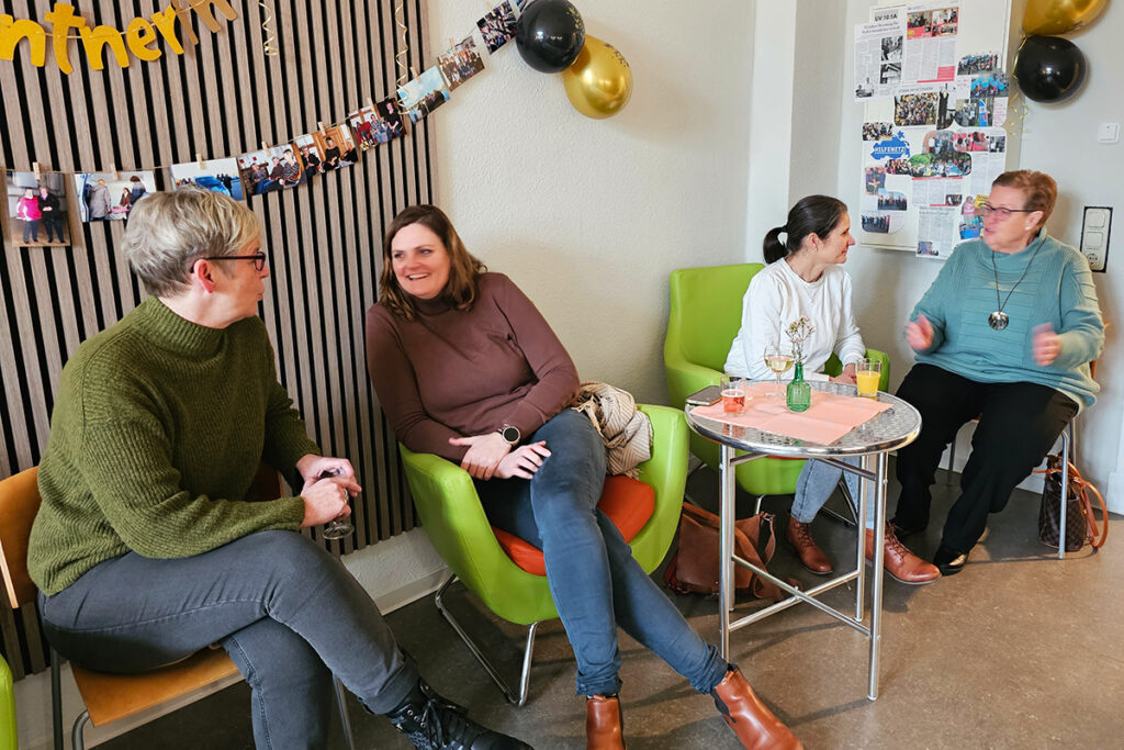 Vier Frauen sitzen in einer gem&uuml;tlichen Umgebung und unterhalten sich.