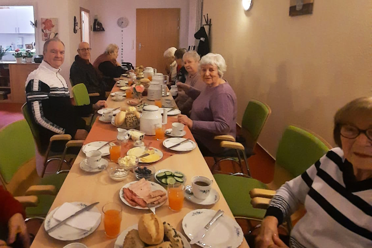 Ältere Menschen beim gemeinsamen Frühstückstisch