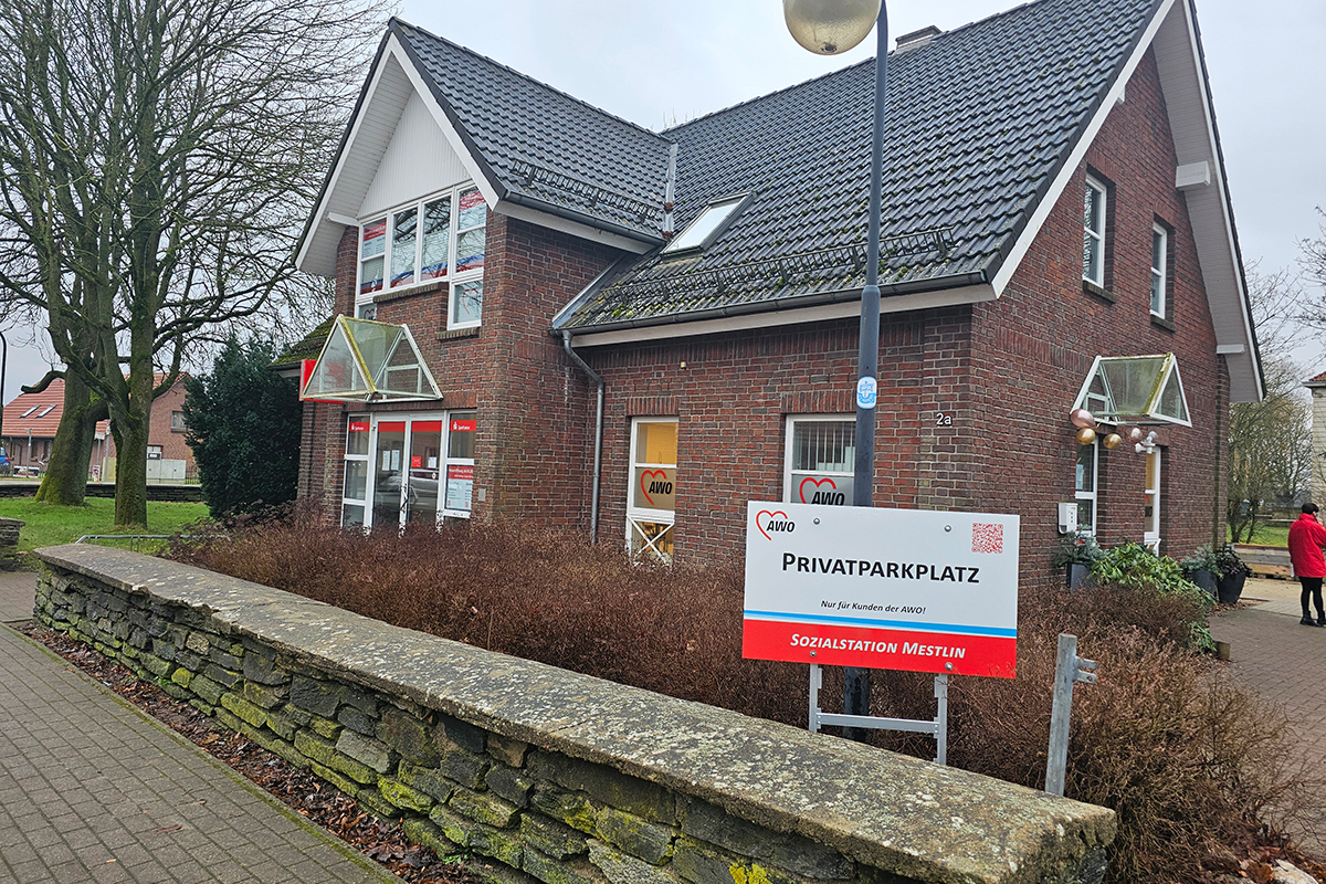 Ansicht eines Backsteingebäudes mit AWO-Logo und Parkplatzschild