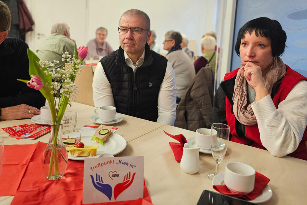 Menschen bei einer AWO-Veranstaltung sitzend an einem Tisch