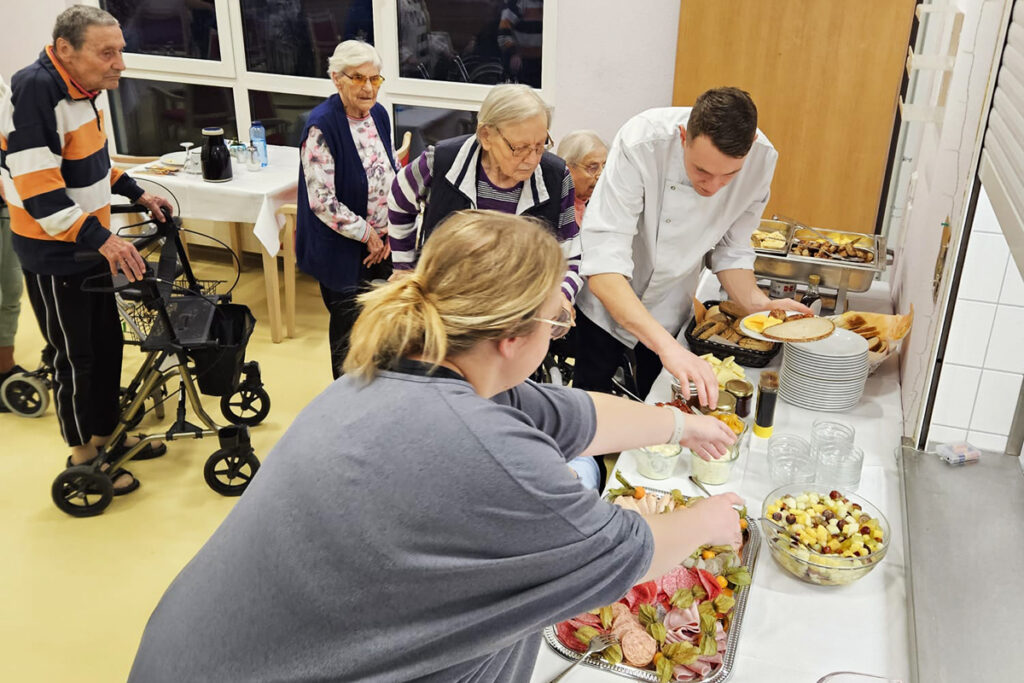 Menschen in einem Speisesaal beim Buffet