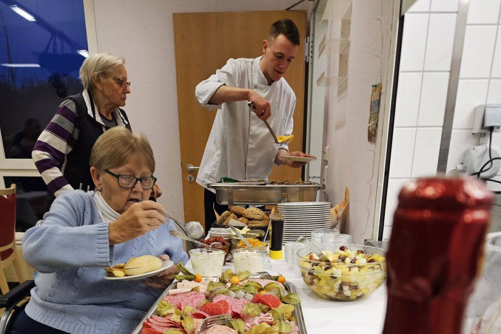Menschen bedienen sich an einem Buffet.