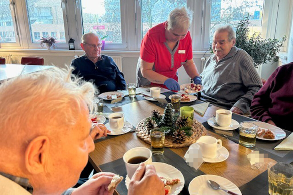 Personen beim gemeinsamen Essen in einem Gemeinschaftsraum