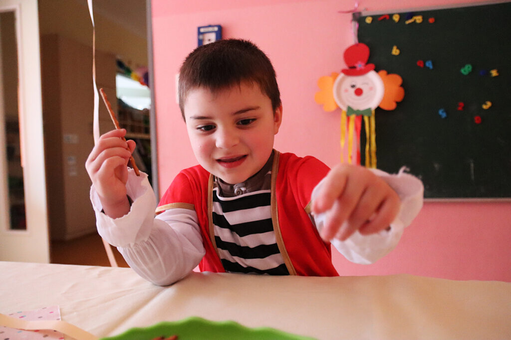 Ein Kind in einem Piratenkost&uuml;m beim Spielen an einem Tisch.