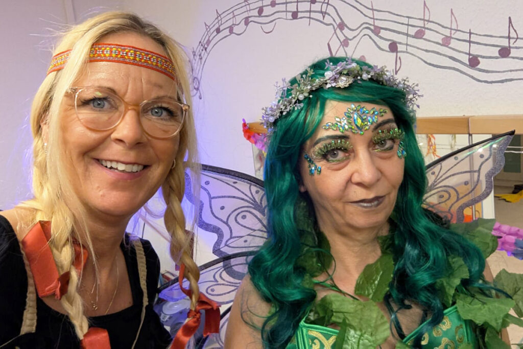 Zwei Frauen in fantasievollen Kost&uuml;men posieren l&auml;chelnd.