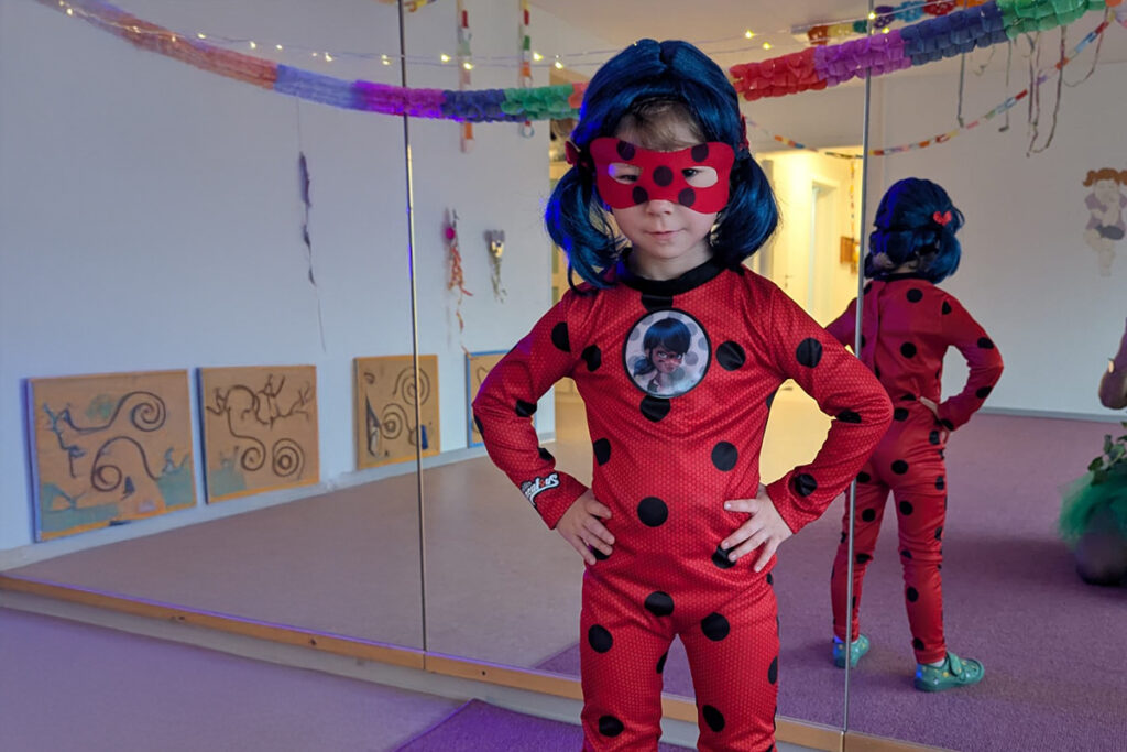 Kind im Marienk&auml;ferkost&uuml;m vor einer Spiegelwand
