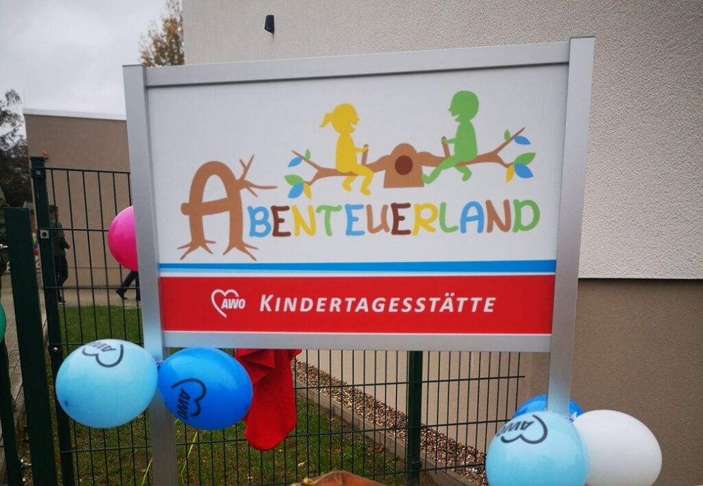 Schild mit Aufschrift 'Abenteuerland - AWO Kindertagesstätte'