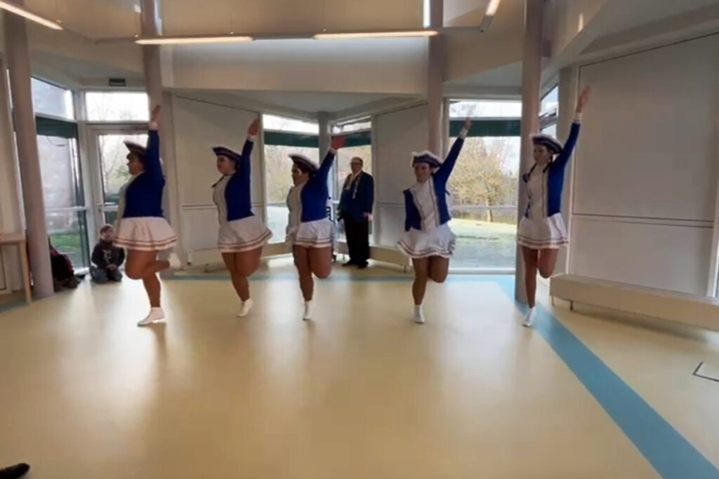 Tanzgruppe in Uniform tanzt in einem Raum