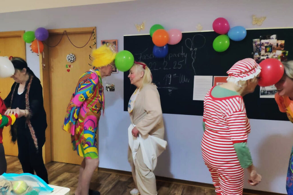 Menschen verkleidet bei einer Feier mit Luftballons