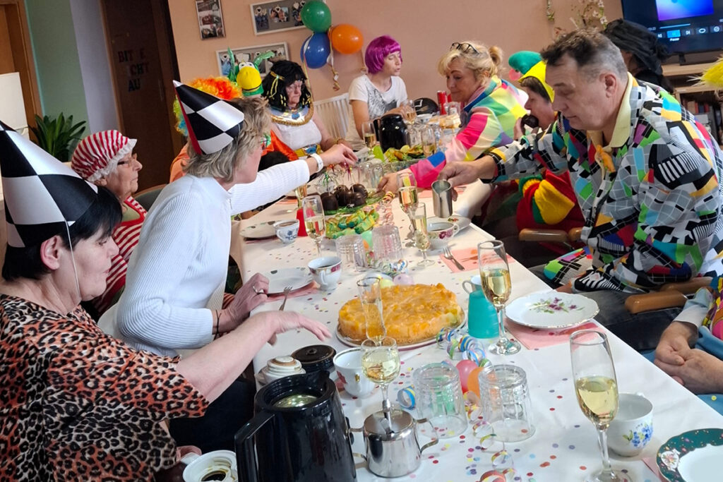 Gruppe von Menschen bei einer Feier in einem geschm&uuml;ckten Raum