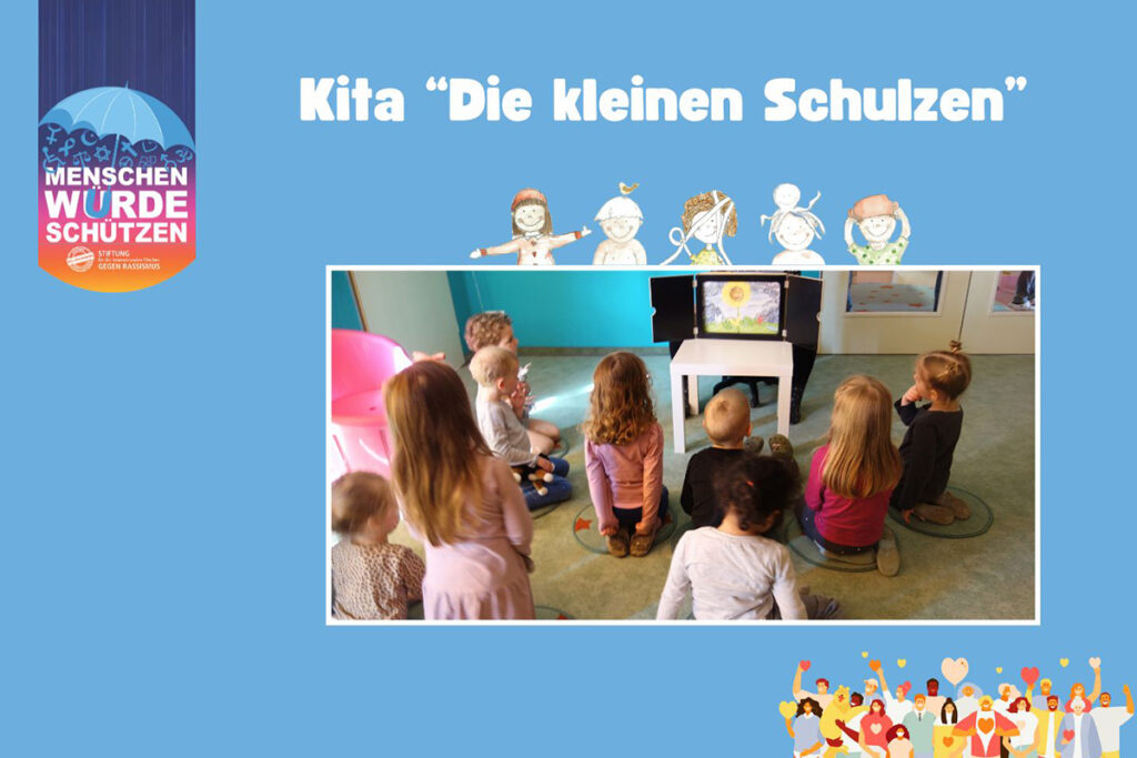 Kinder in einer Kita sitzen vor einem kleinen Theater.