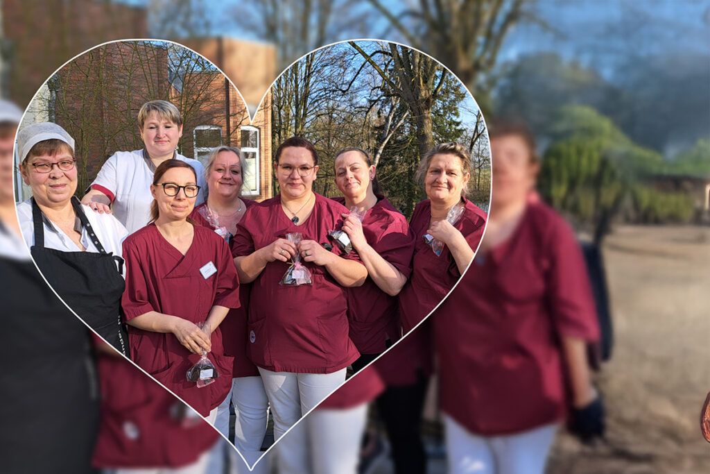 Eine Gruppe von Frauen in pflegerischer Kleidung steht zusammen, wobei der Hintergrund unscharf ist und der Fokus auf die Gruppe in Herzform gerahmt ist.