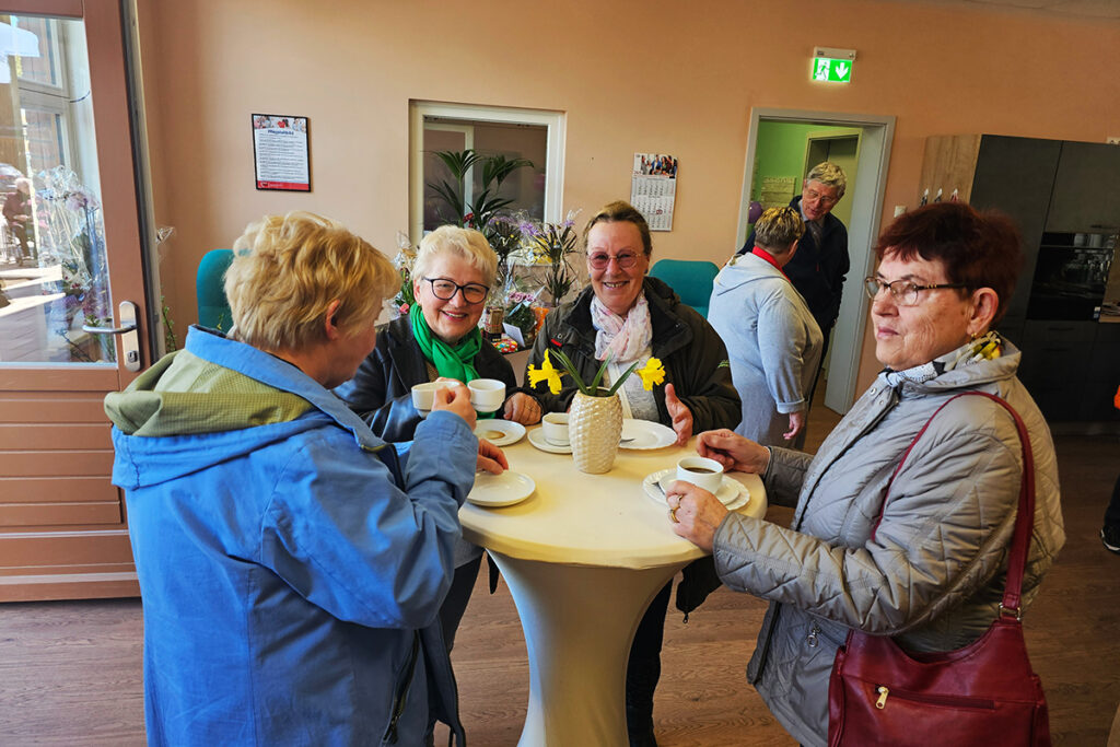 Gruppe von Senioren beim Kaffeetrinken an einem Stehtisch