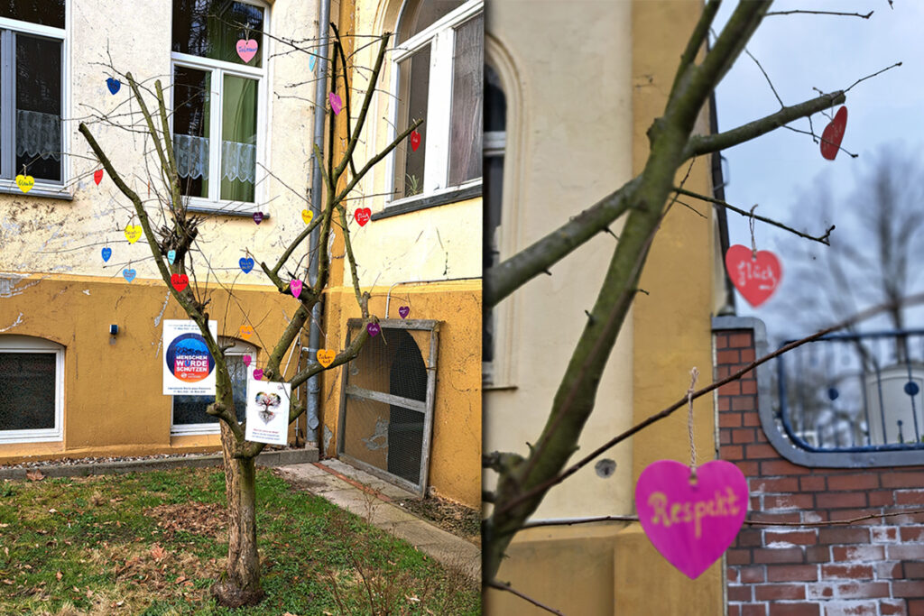 Ein Baum mit dekorativen Herzen vor einem Geb&auml;ude.