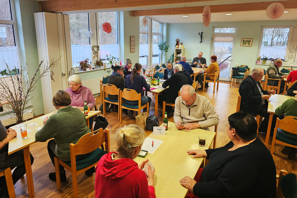 Menschen bei einem Kartenspiel in einem Gemeinschaftsraum