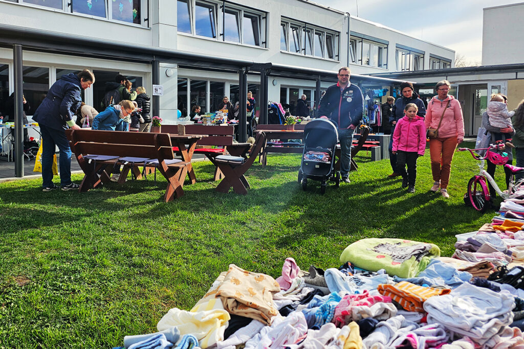 Menschen bei einem Flohmarkt im Freien vor einem Geb&auml;ude