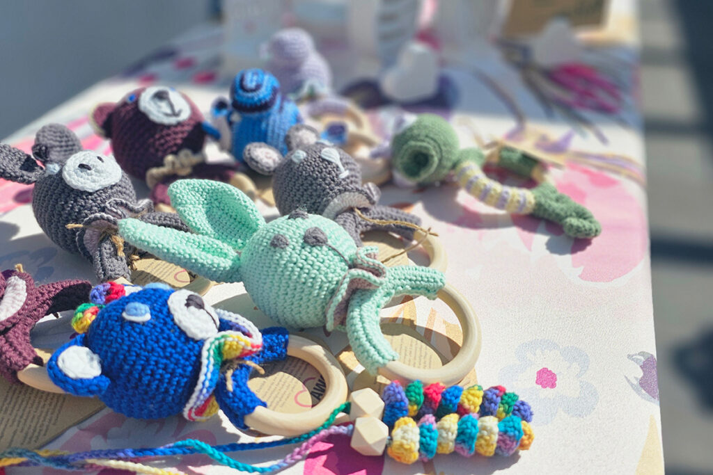 Ein Tisch mit mehreren geh&auml;kelten Bei&szlig;ringen in Form von Tieren.