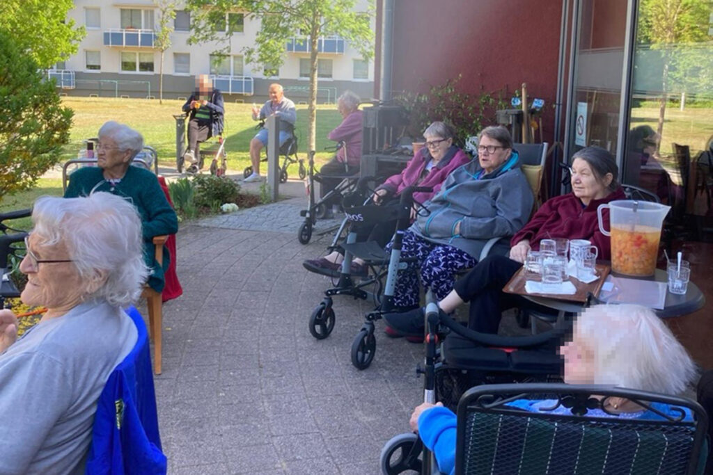 &Auml;ltere Menschen sitzen im Freien mit Rollatoren