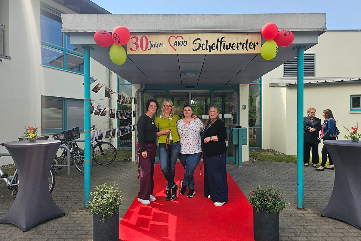 Gruppenfoto vor AWO-Standort mit Jubiläumsdekoration