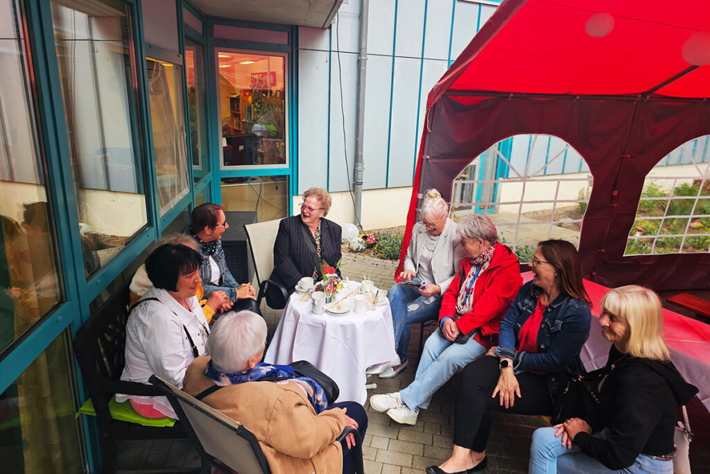 Eine Gruppe &auml;lterer Damen sitzt drau&szlig;en an einem Tisch.