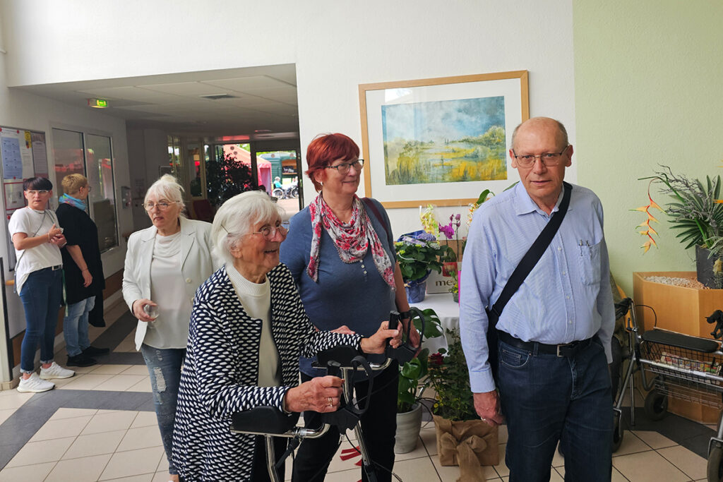 Menschen in einem Flur, darunter &auml;ltere Personen mit einem Rollator.