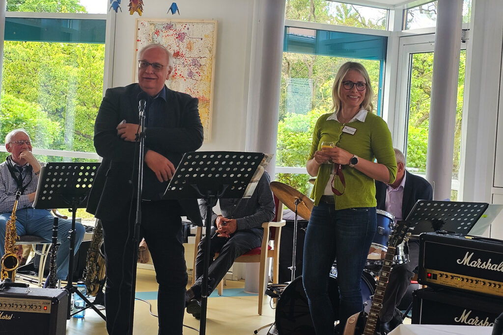 Personen bei einer Veranstaltung mit Musikinstrumenten im Hintergrund