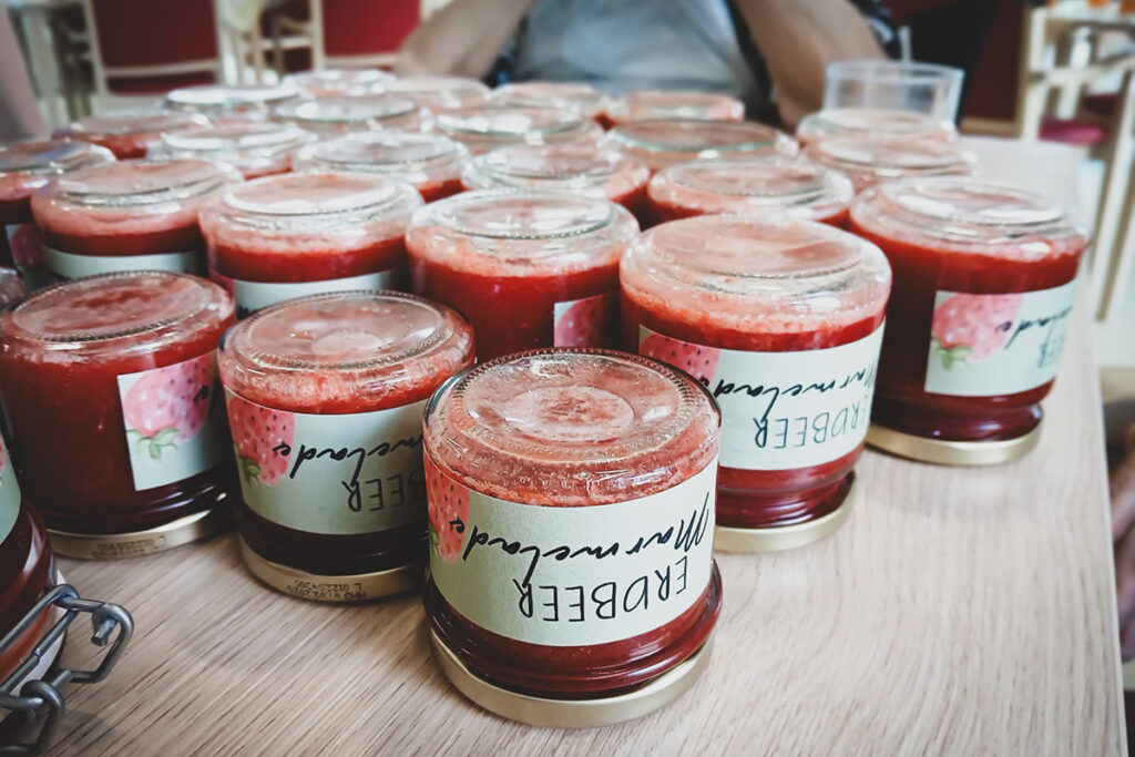 Viele Gl&auml;ser mit Erdbeermarmelade auf einem Tisch