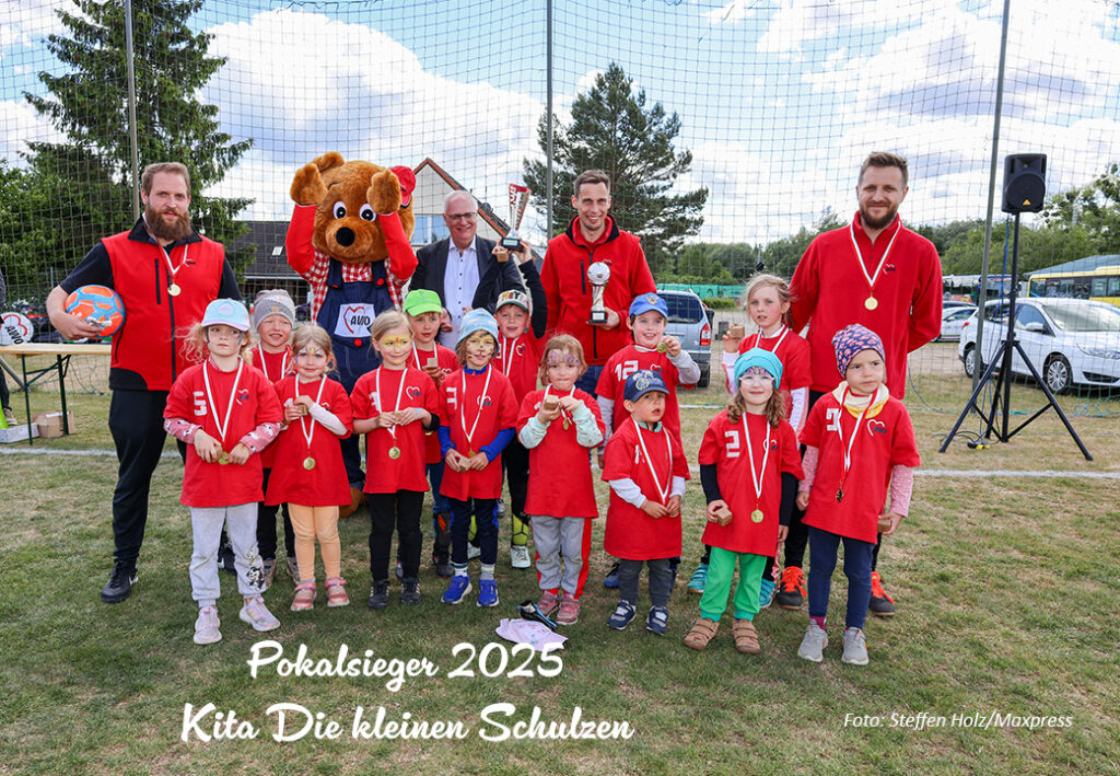 Gruppenfoto mit Kindern und Erwachsenen auf einem Sportfeld