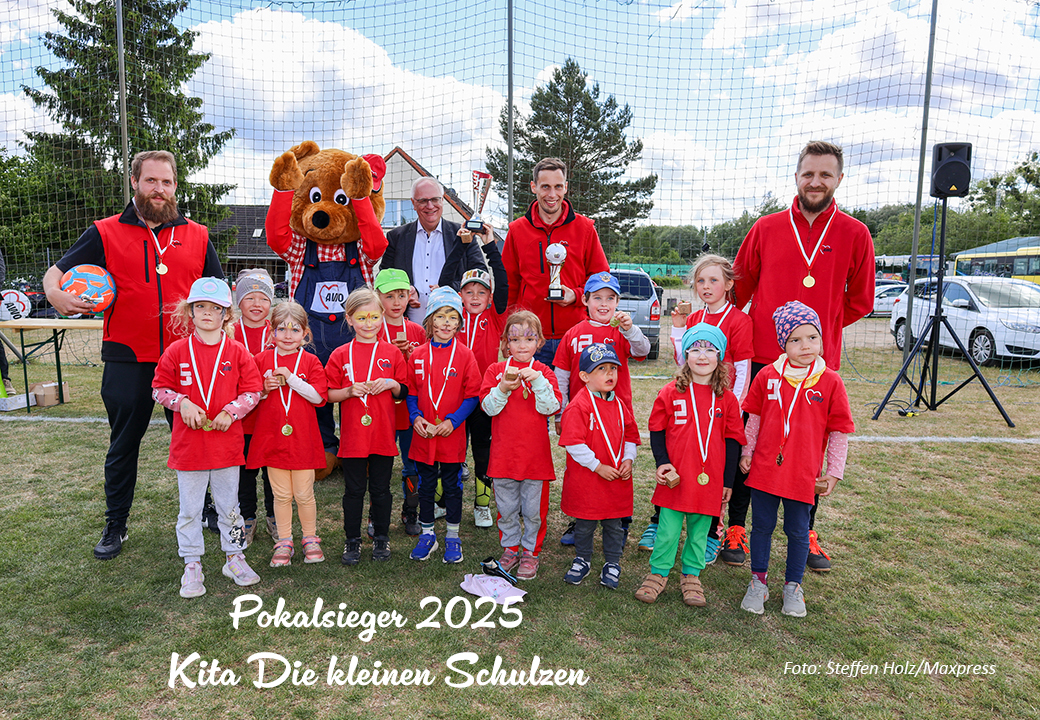 Gruppenfoto mit Kindern und Erwachsenen auf einem Sportfeld