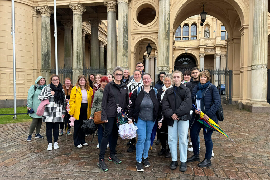 Gruppe von Menschen vor dem Schweriner Schlo&szlig; mit S&auml;ulen