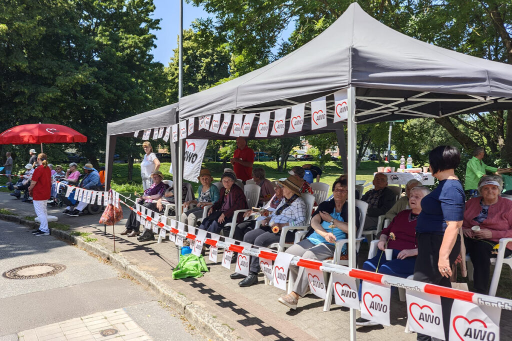 Menschen bei einem AWO-Event unter einem Pavillon sitzend