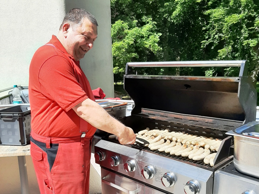 Mann grillt Würste auf einem großen Grill