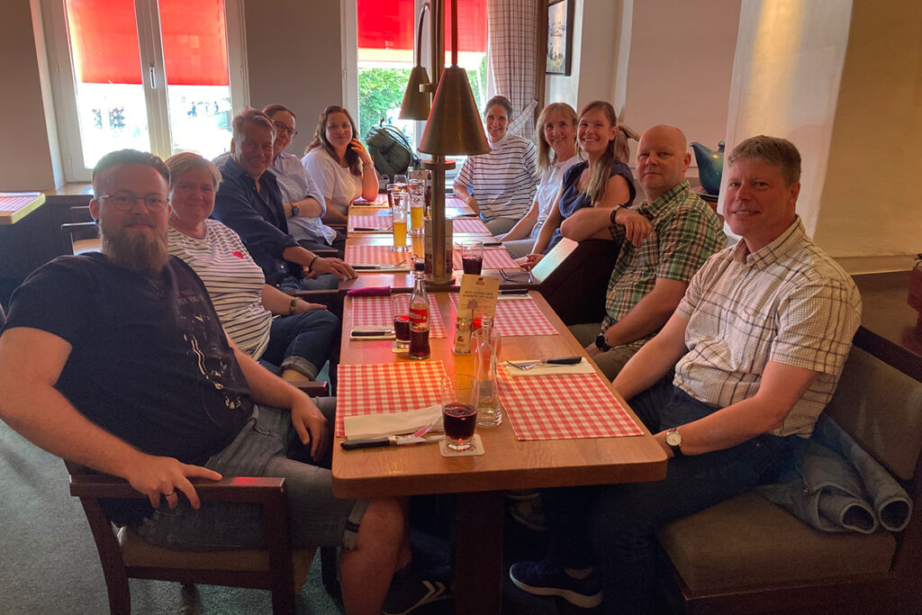 Eine Gruppe von Personen sitzt an einem langen Tisch in einem Restaurant.