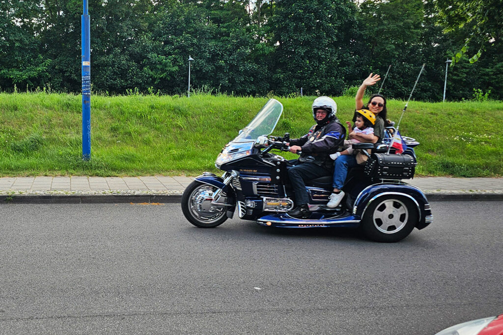 Drei Personen auf einem Motorradtrike auf einer Stra&szlig;e
