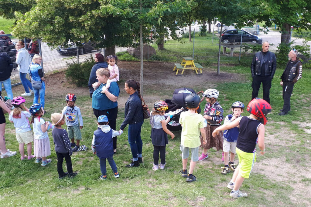 Eine Gruppe von Kindern und Erwachsenen versammelt sich im Freien.
