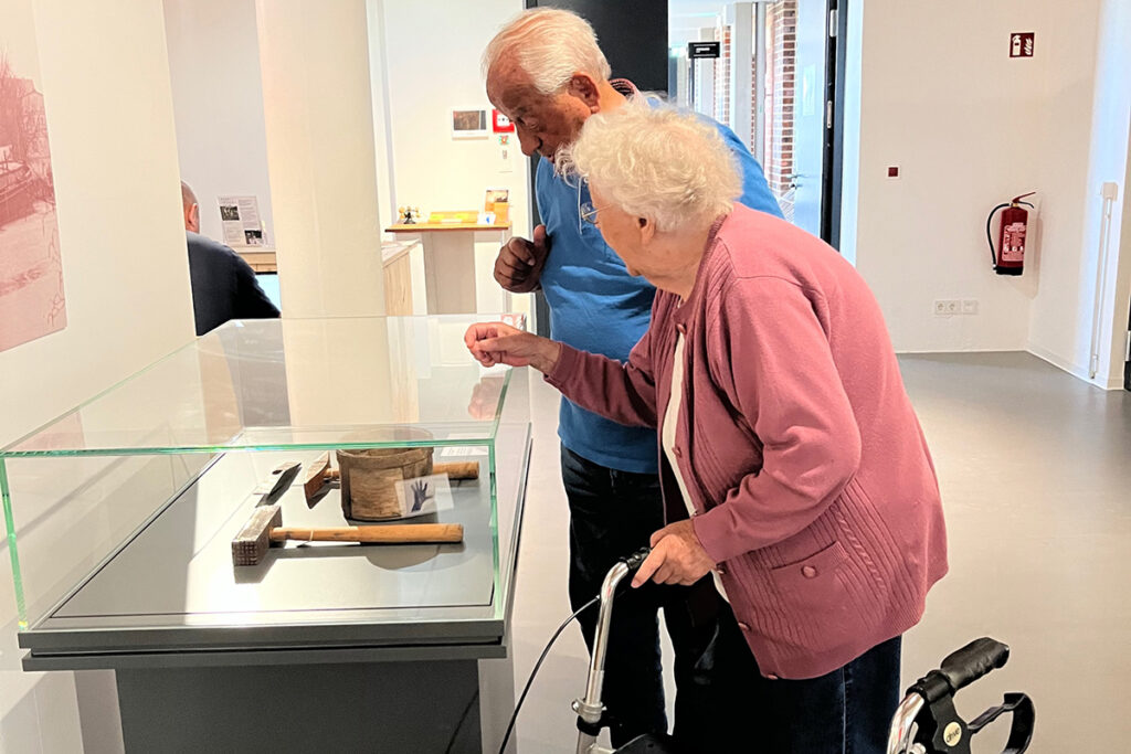 Ältere Personen betrachten Exponate in einem Museum