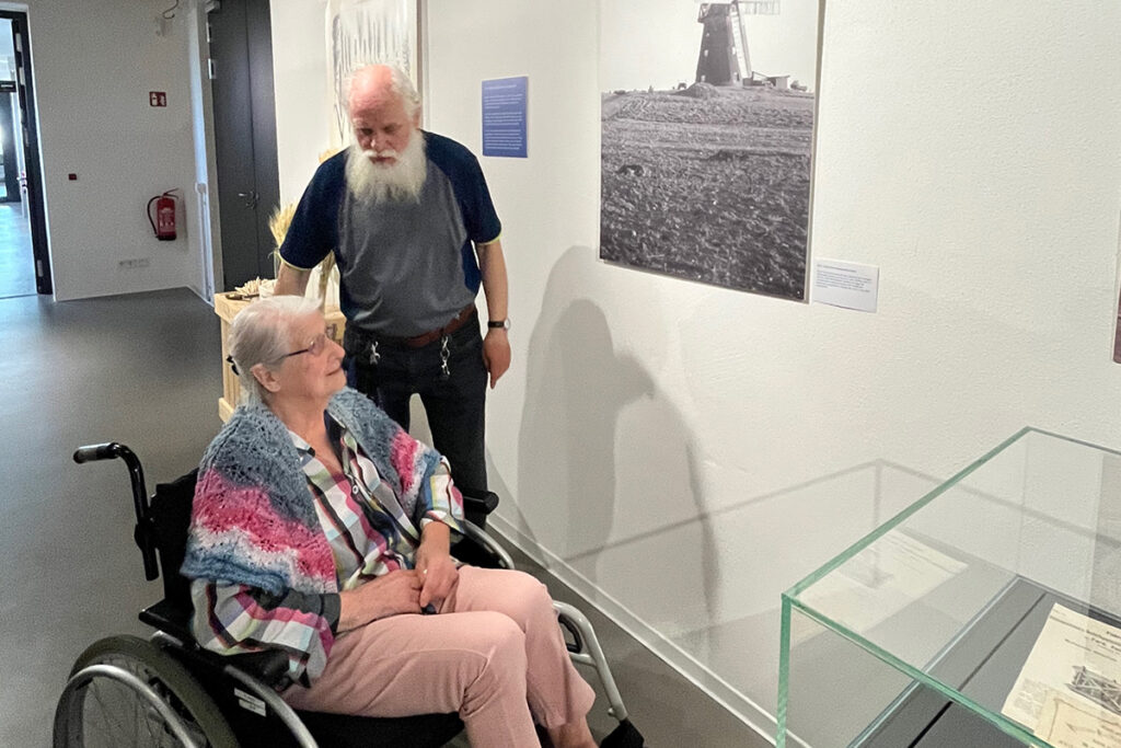 Ein &auml;lteres Paar betrachtet ein Bild in einer Ausstellung.
