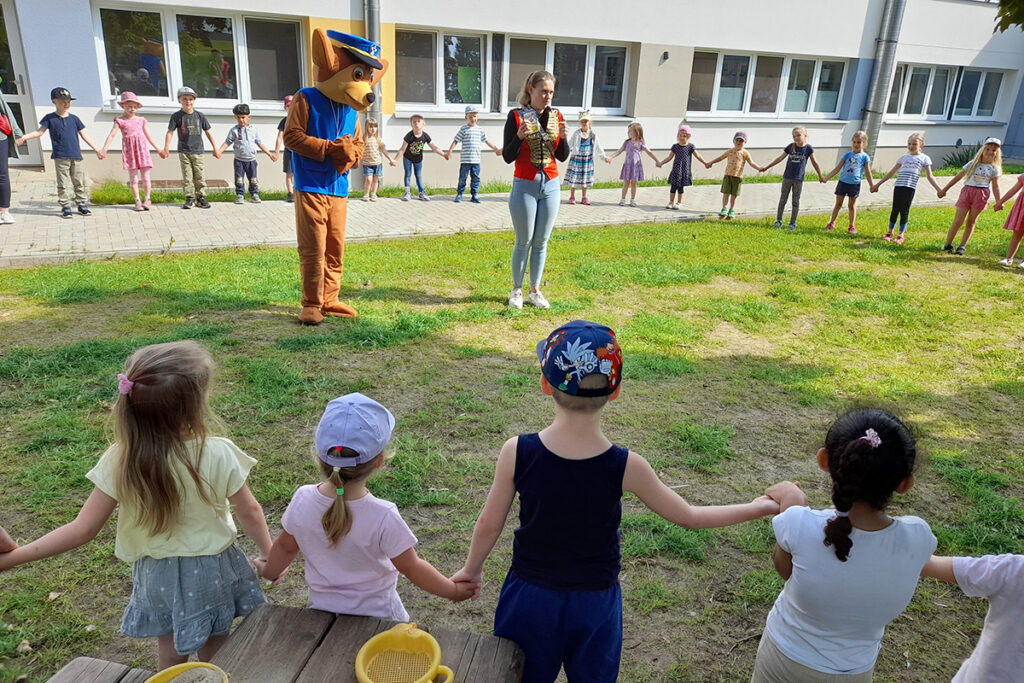 Kinder in einem Kreis im Freien, einige in Kost&uuml;men